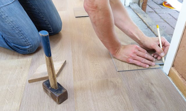 someone putting in wooden flooring