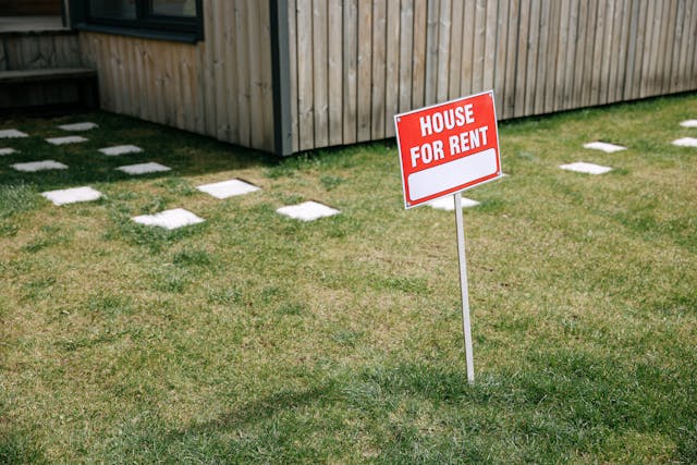 a house for rent sign in a front yard