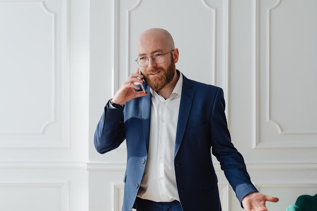 man in blue suit talking over the phone