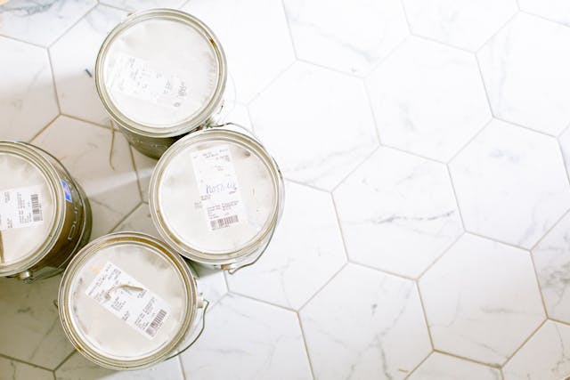 four paint cans on hexagonal-tiled floor