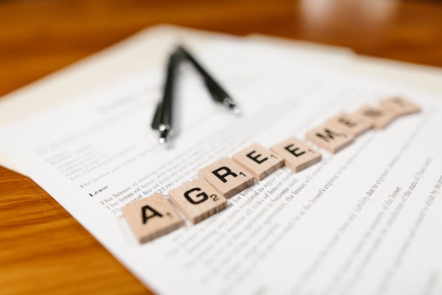 two pens and scrabble tiles that spell out 