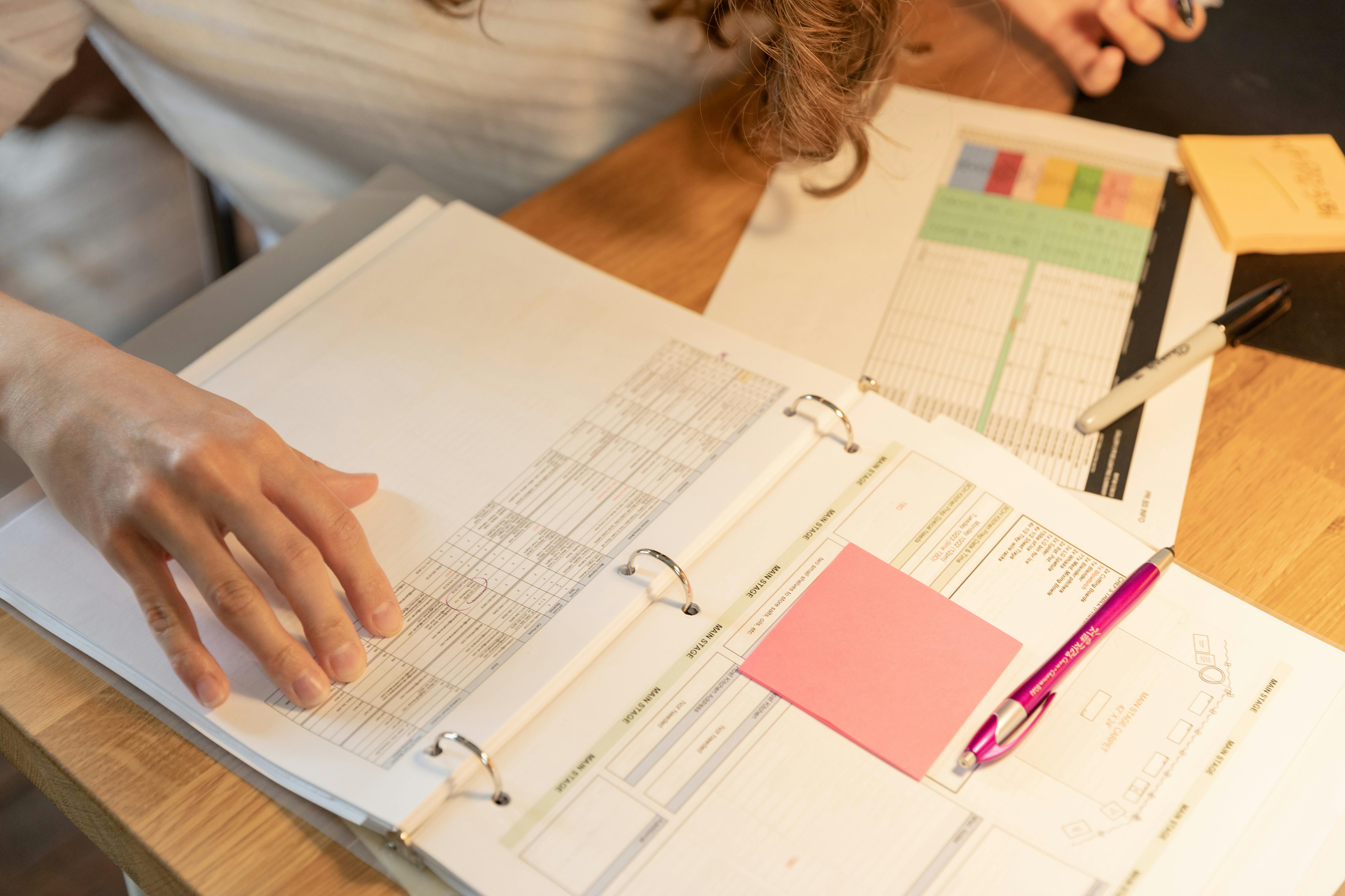 someone looking at records and a colour-coded schedule