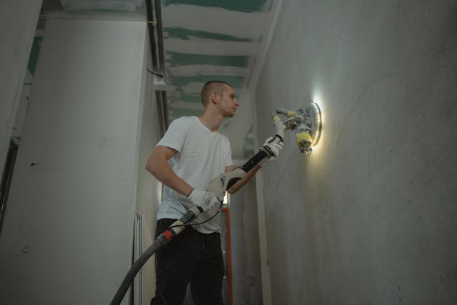 someone sanding a wall