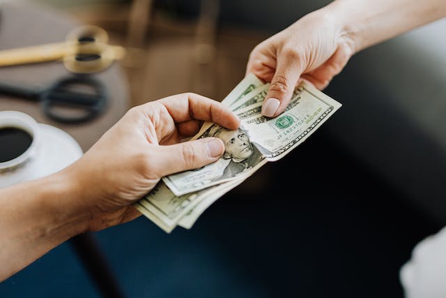 person handing over money to another person for their investment property